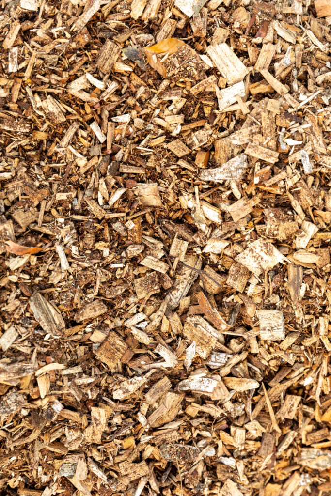 Wood chip delivery in Kingston with arborist dumping fresh mulch in residential driveway